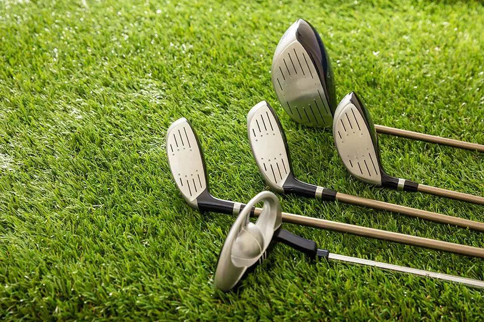 Golf clubs on green grass golf course