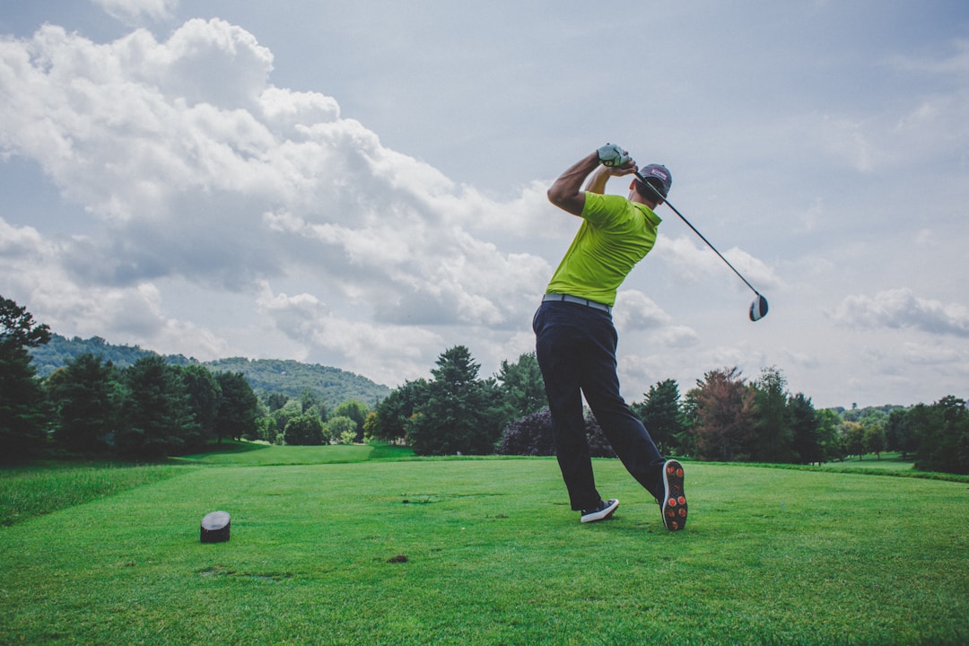 Golfer in mid-swing showing follow-through on a golf course